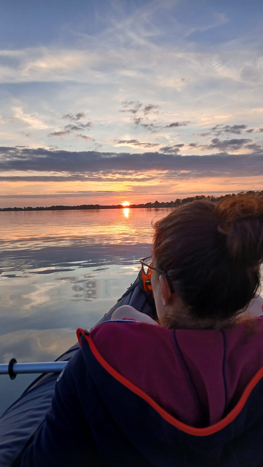 Susi Nocker im Paddelboot auf ruhigem Wasser bei Sonnenuntergang